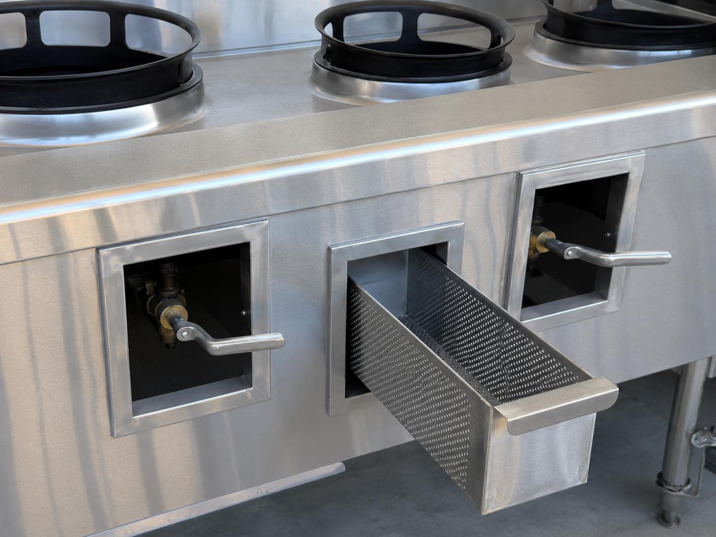 Round perforated stainless steel basket in a wok range well